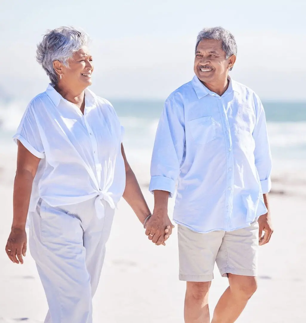 Smiling senior couple holding hands on beach